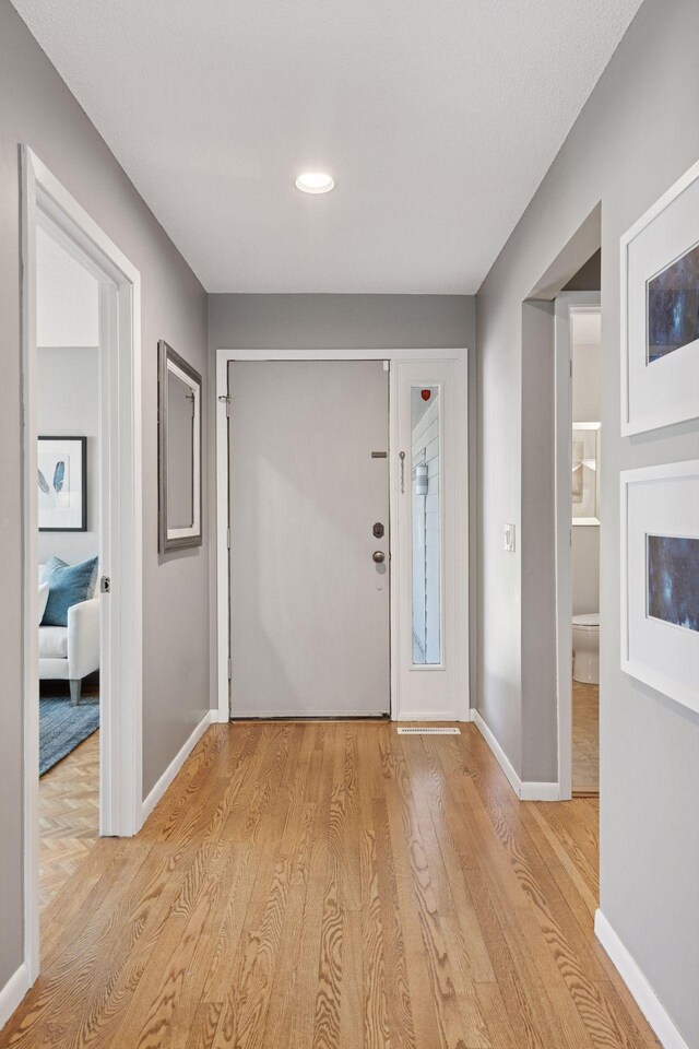 foyer entrance featuring light wood-style floors, recessed lighting, and baseboards