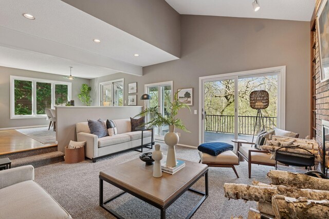 living area with a healthy amount of sunlight, carpet floors, baseboards, and a brick fireplace