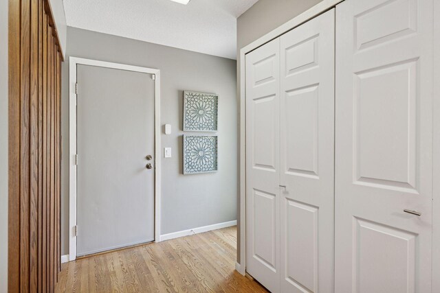 foyer featuring light wood-style floors and baseboards