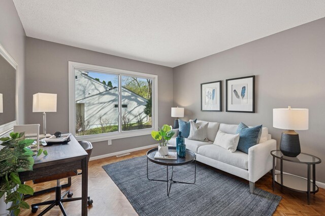 living area featuring baseboards, a textured ceiling, and visible vents