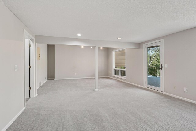 below grade area with baseboards, recessed lighting, a textured ceiling, and light carpet