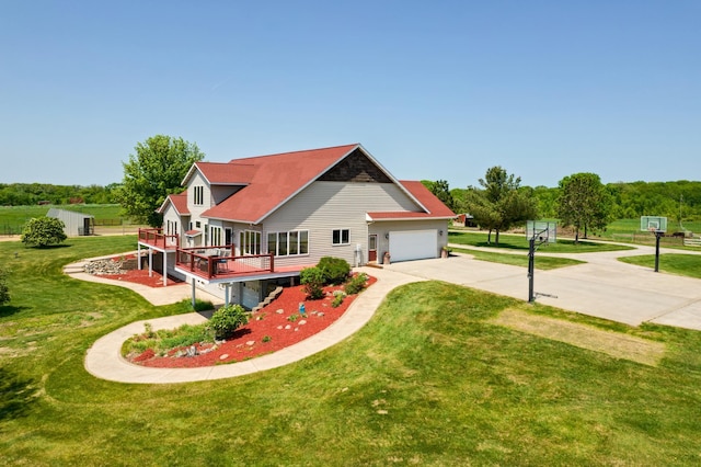 rear view of property featuring a lawn, concrete driveway, and a deck