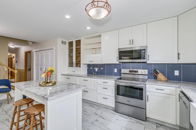 kitchen featuring visible vents, appliances with stainless steel finishes, white cabinets, marble finish floor, and recessed lighting