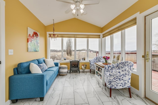 living room with a ceiling fan, baseboards, vaulted ceiling, and marble finish floor