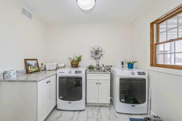 clothes washing area with visible vents, marble finish floor, cabinet space, and independent washer and dryer