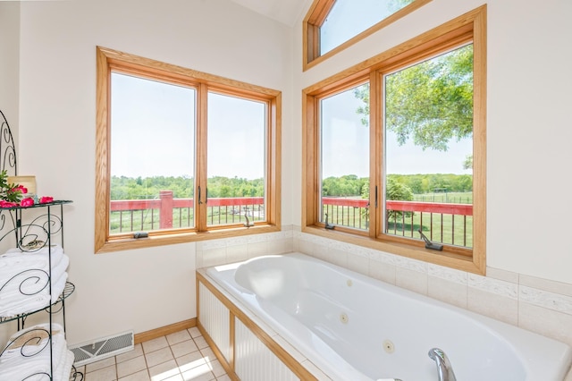 bathroom featuring tile patterned floors, baseboards, a whirlpool tub, and visible vents