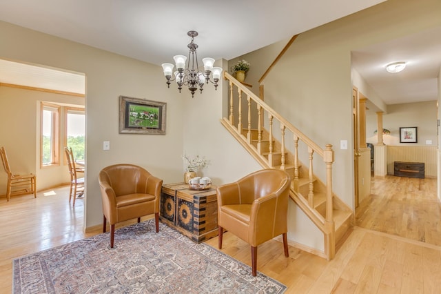 interior space with stairs, baseboards, a notable chandelier, and wood finished floors
