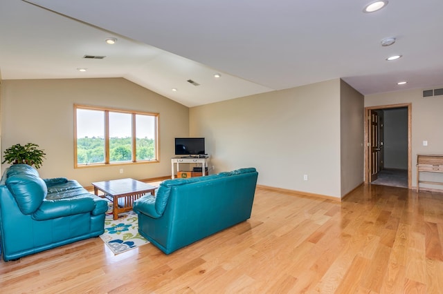 living area featuring visible vents, light wood-style floors, and lofted ceiling