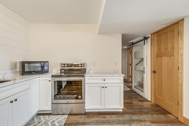 kitchen with stainless steel electric range oven, black microwave, a barn door, and dark wood-style floors