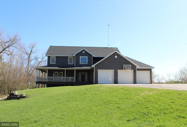 view of front facade featuring covered porch, an attached garage, driveway, and a front yard