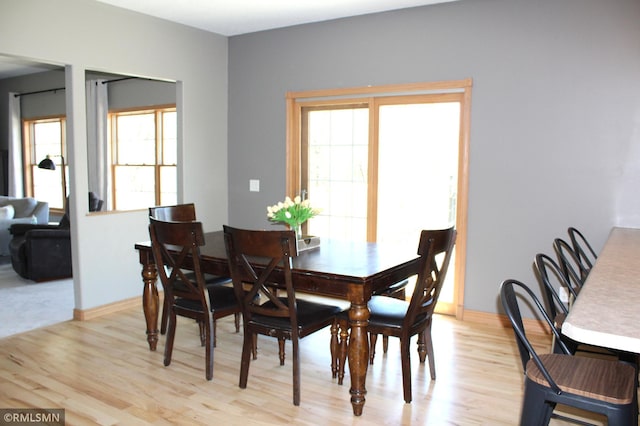 dining room featuring baseboards and light wood-style flooring