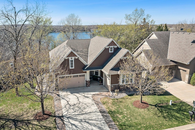 5435 Yellowstone Trl, Minnetrista, MN 55331 - craftsman-style house with stone siding, driveway, an attached garage, roof with shingles, and a front yard
