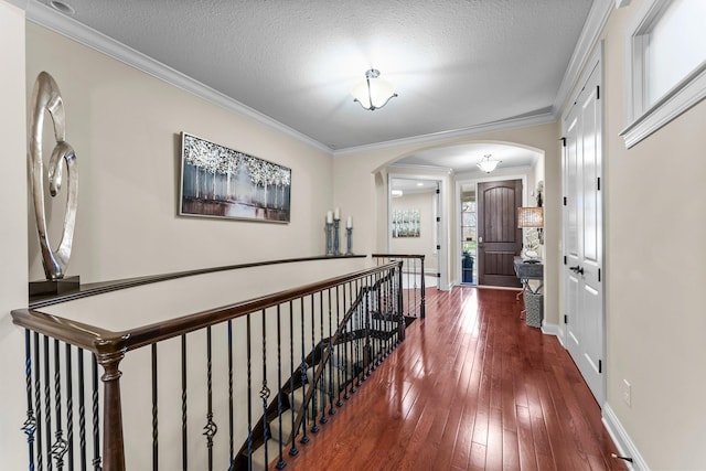 5435 Yellowstone Trl, Minnetrista, MN 55331 - foyer entrance with arched walkways, hardwood / wood-style flooring, crown molding, baseboards, and a textured ceiling