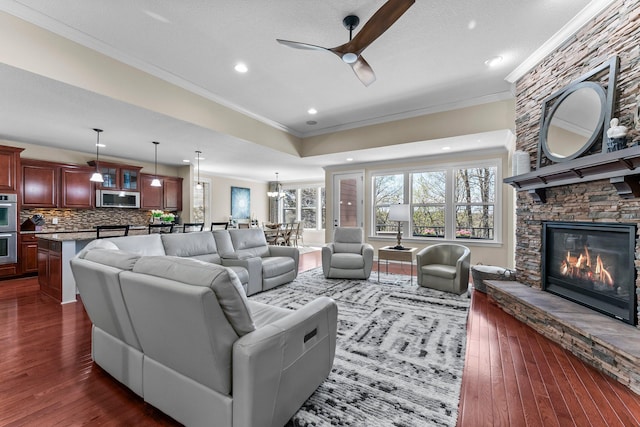 5435 Yellowstone Trl, Minnetrista, MN 55331 - living area with crown molding, a ceiling fan, a fireplace, dark wood-type flooring, and recessed lighting