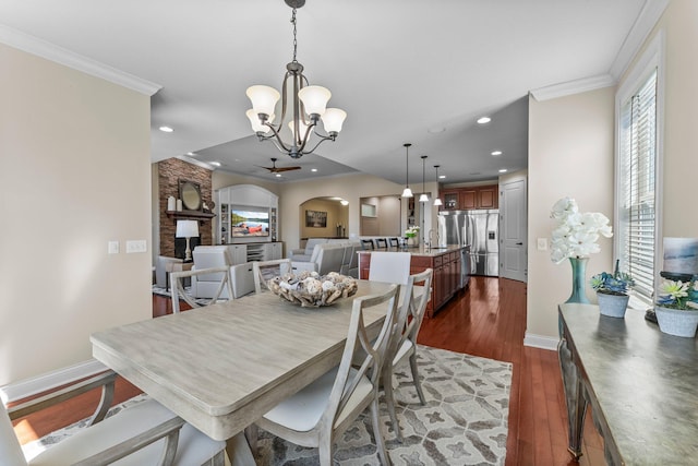 5435 Yellowstone Trl, Minnetrista, MN 55331 - dining space featuring arched walkways, a chandelier, dark wood-type flooring, ornamental molding, and baseboards