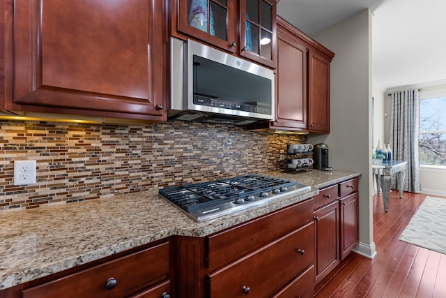 5435 Yellowstone Trl, Minnetrista, MN 55331 - kitchen featuring stainless steel appliances, dark wood-style floors, glass insert cabinets, light stone countertops, and baseboards