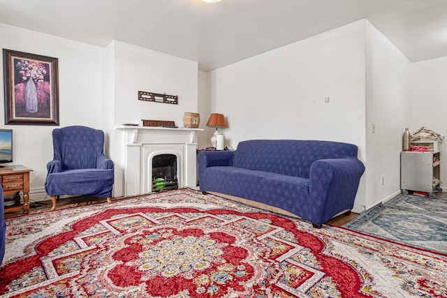 living area with baseboards and a fireplace