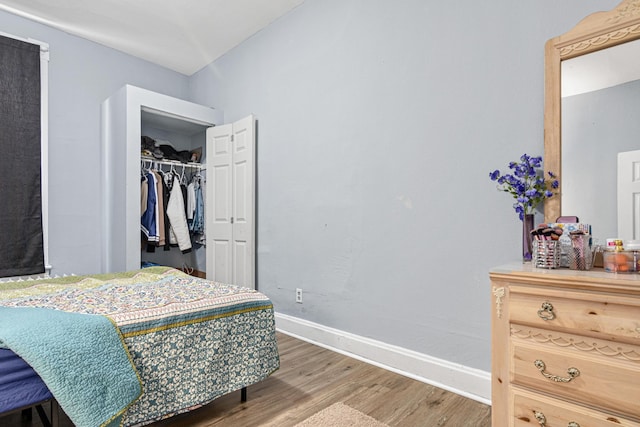 bedroom with baseboards, a closet, and wood finished floors