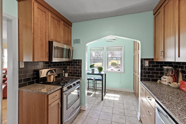 kitchen featuring visible vents, baseboards, tasteful backsplash, appliances with stainless steel finishes, and light tile patterned floors