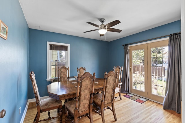 dining room featuring a ceiling fan, baseboards, and light wood-type flooring