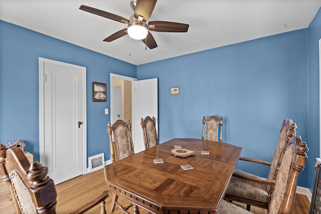 dining area with visible vents, a ceiling fan, baseboards, and wood finished floors