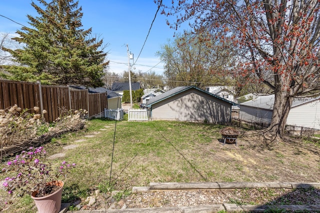 view of yard featuring a fenced backyard and a fire pit