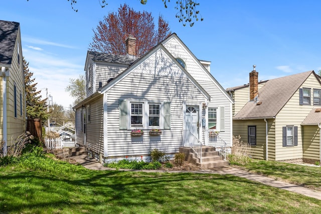 back of property with a lawn, a chimney, and entry steps