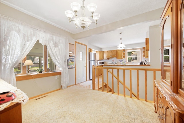 517 2nd St, Waconia, MN 55387 - kitchen featuring freestanding refrigerator, a chandelier, light colored carpet, pendant lighting, and light countertops