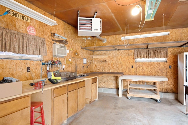 517 2nd St, Waconia, MN 55387 - garage with a wall mounted air conditioner, a workshop area, freestanding refrigerator, and a heating unit