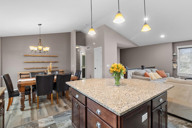 1226 1st St, Saint Paul Park, MN 55071 - kitchen featuring an inviting chandelier, a kitchen island, light stone countertops, vaulted ceiling, and decorative light fixtures