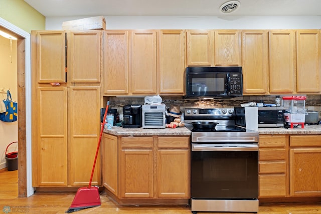 803 10th Ave N, Fargo, ND 58102 - kitchen featuring light brown cabinetry, appliances with stainless steel finishes, light wood-type flooring, backsplash, and visible vents