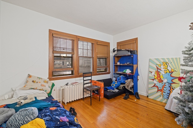 803 10th Ave N, Fargo, ND 58102 - bedroom featuring baseboards, radiator heating unit, and wood finished floors