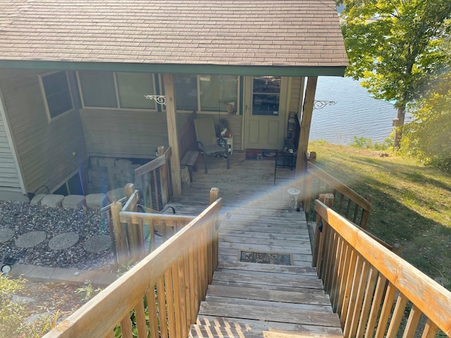 property entrance with a water view and a shingled roof