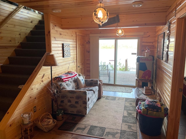 tiled living room featuring wood walls, wood ceiling, and stairway