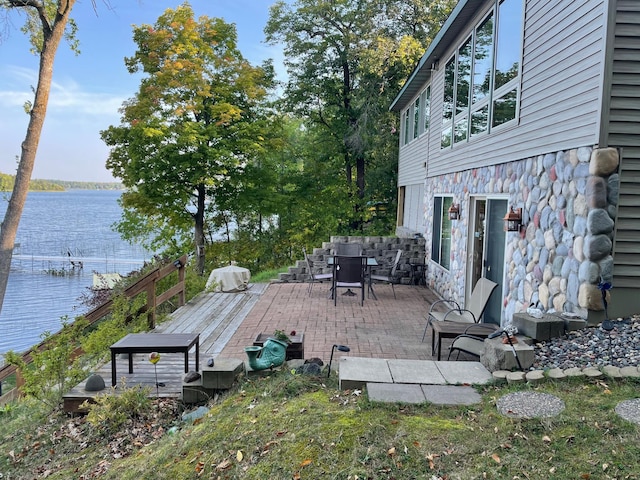 deck featuring a water view and outdoor dining area