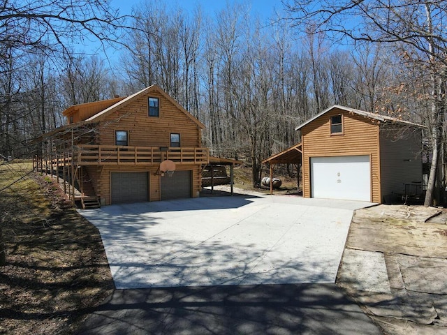 20703 Aspen Dr, Grand Rapids, MN 55744 - view of home's exterior featuring a garage, an outbuilding, a deck, and concrete driveway