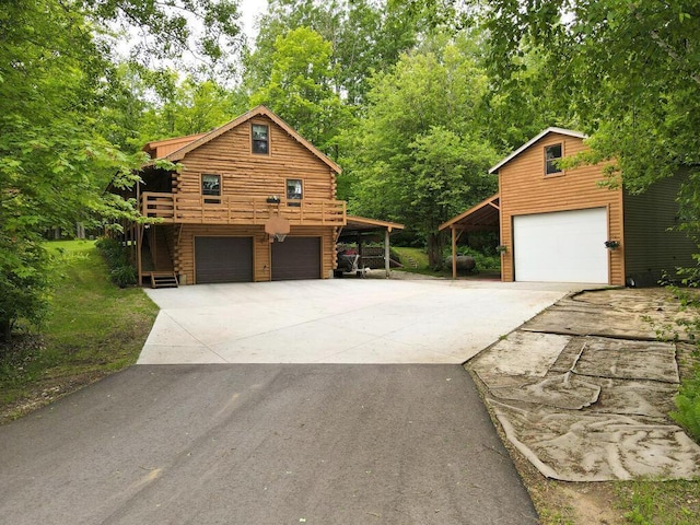 20703 Aspen Dr, Grand Rapids, MN 55744 - view of side of home with a garage, concrete driveway, and log exterior