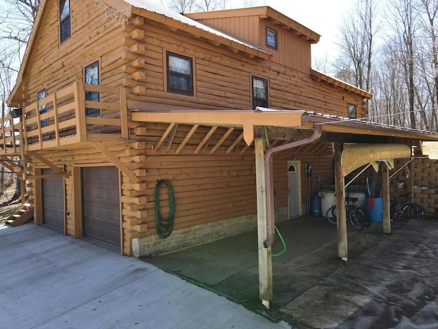 20703 Aspen Dr, Grand Rapids, MN 55744 - view of property exterior with an attached garage, log siding, a metal roof, and driveway