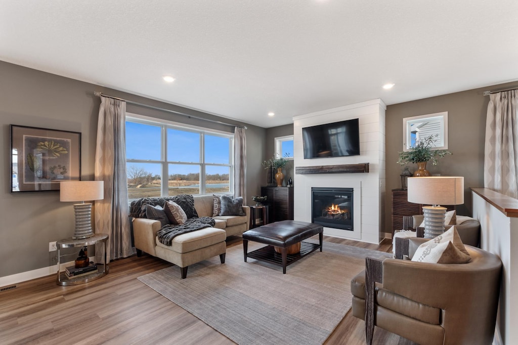 4336 130th Ct NE, Blaine, MN 55449 - living room featuring visible vents, a large fireplace, light wood-type flooring, baseboards, and recessed lighting