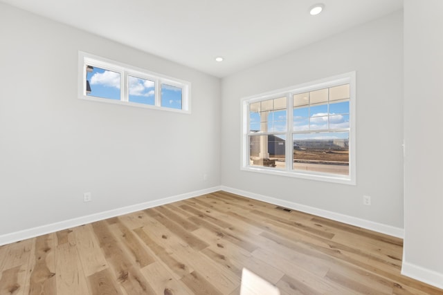 unfurnished room with baseboards, light wood finished floors, and recessed lighting
