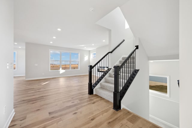 staircase featuring recessed lighting, wood finished floors, and baseboards
