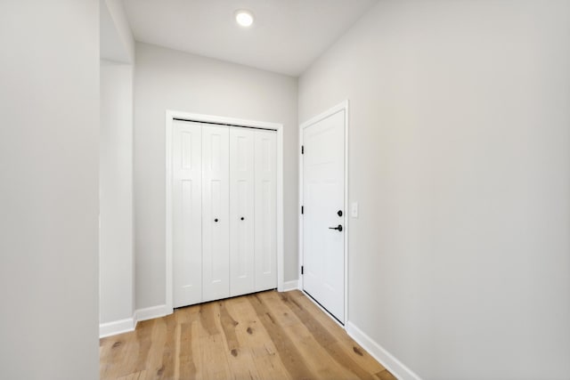 corridor featuring light wood-type flooring, baseboards, and recessed lighting