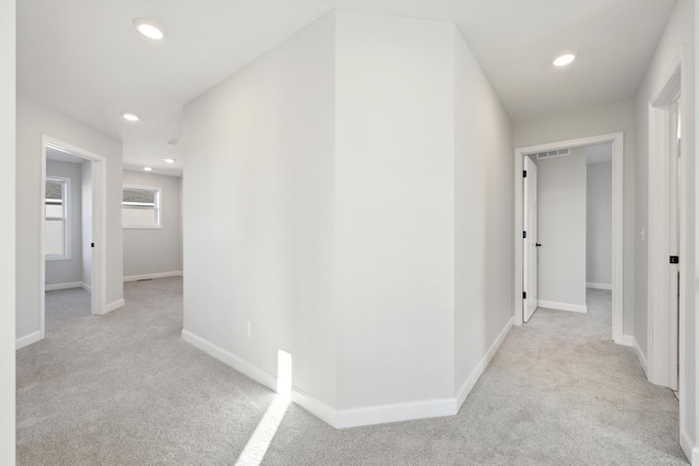 hallway with carpet flooring, recessed lighting, and baseboards