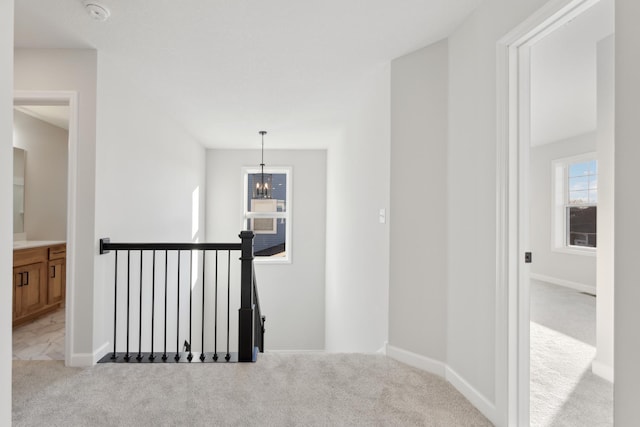 corridor featuring an upstairs landing, carpet floors, healthy amount of natural light, and baseboards