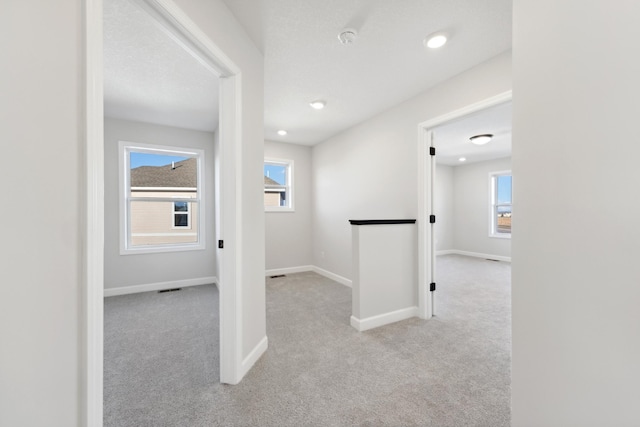 hallway with carpet floors, baseboards, and recessed lighting