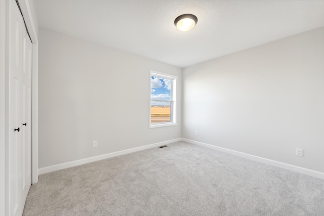 unfurnished bedroom with carpet flooring, a closet, and baseboards