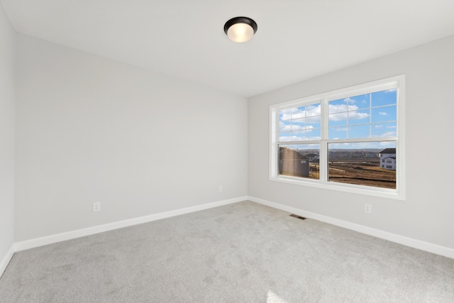 unfurnished room featuring carpet floors and baseboards