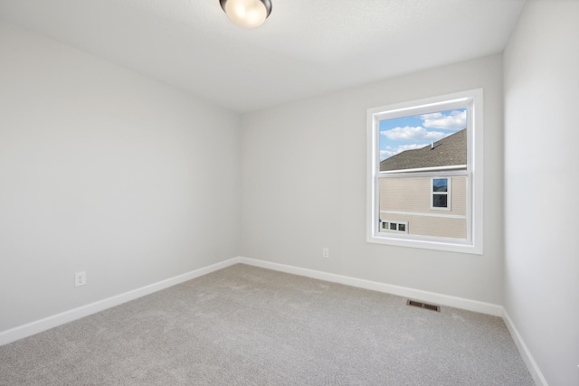 carpeted spare room with baseboards