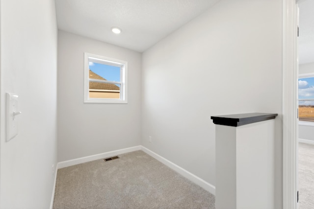 carpeted empty room with baseboards and healthy amount of natural light