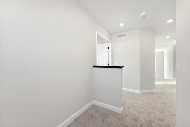 hallway with light colored carpet, baseboards, and recessed lighting